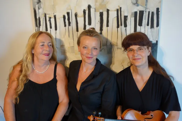 Siso Hagen, Katja Brandl and Katalin Kertész in front of a painting of piano keys