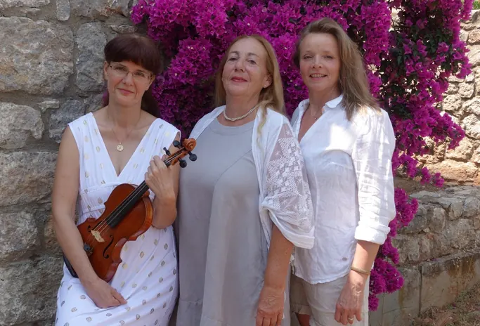 The trio in front of a stone wall with flowering bougainvillea