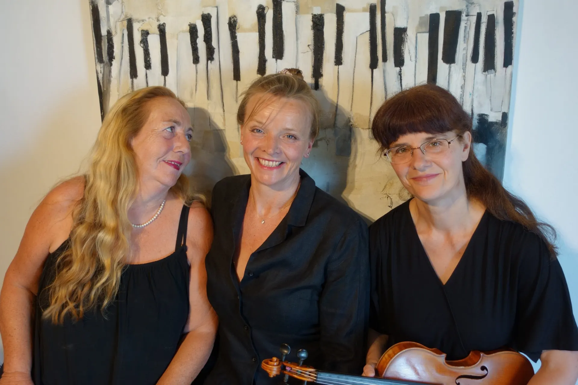 Siso Hagen, Katja Brandl and Katalin Kertész in front of a painting of piano keys
