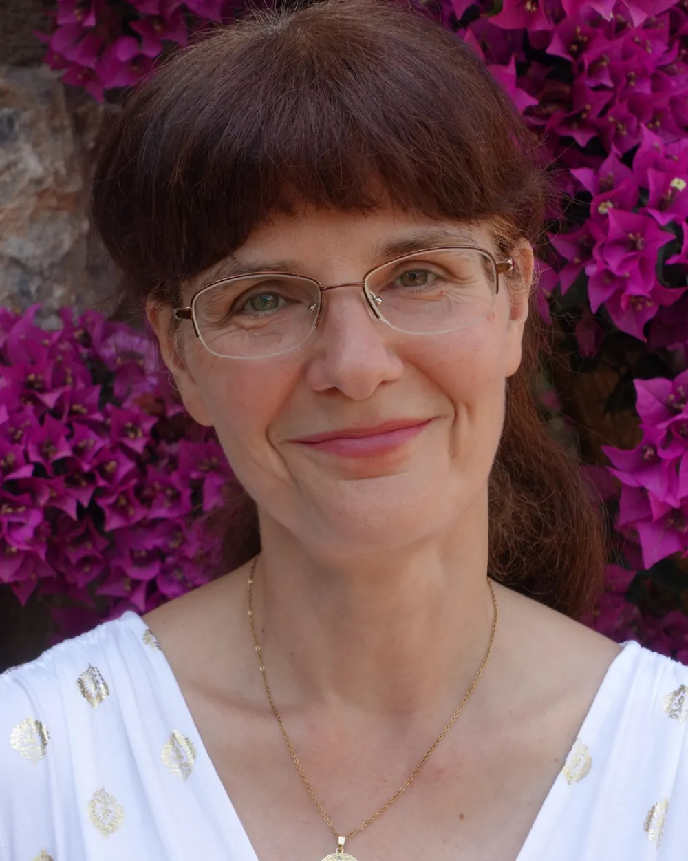 Portrait of violinist Katalin Kertész in front of flowering bougainvillea