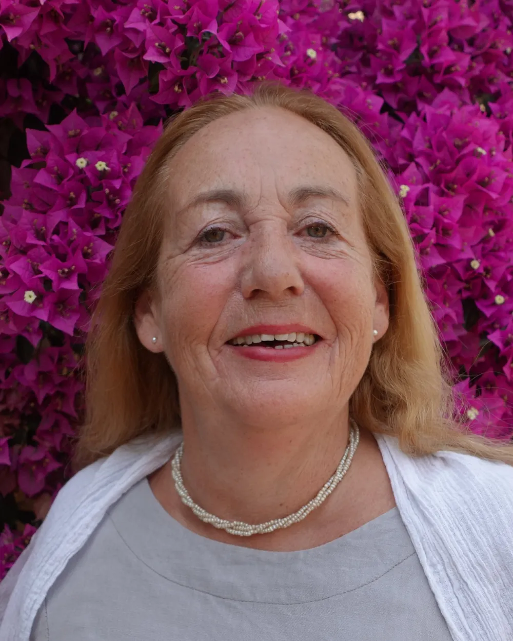 Portrait of pianist Katja Brandl in front of flowering bougainvillea
